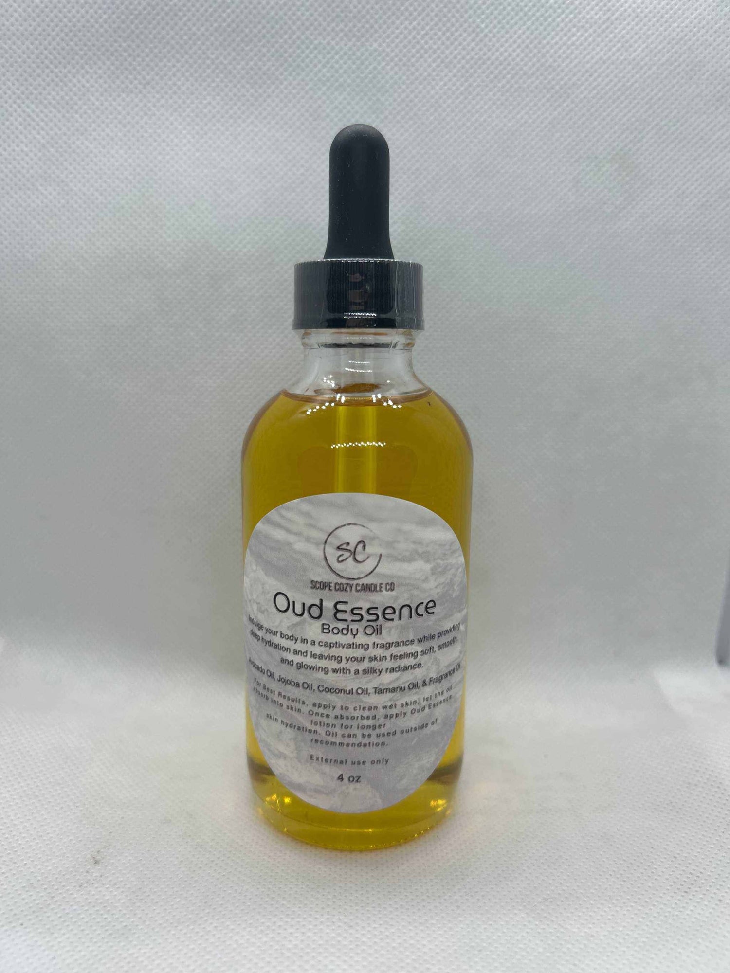 Oud Essence Body Oil 4oz bottle with dropper, moisturizing blend of avocado, jojoba, tamanu, and coconut oils with tonka and oud fragrance