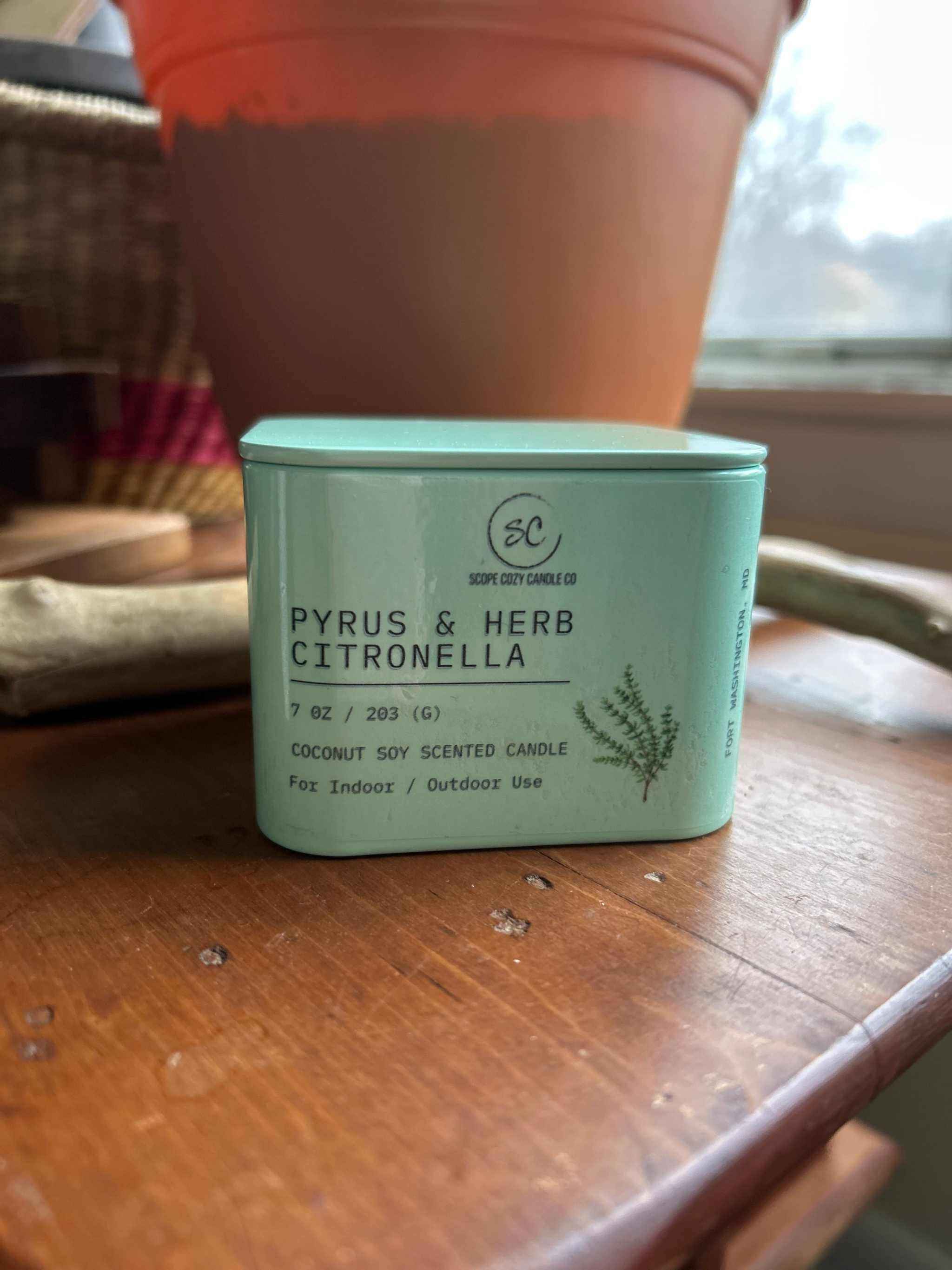 Pyrus &amp; Herb Citronella candle in a green tin, coconut soy scented, designed for indoor and outdoor use.
