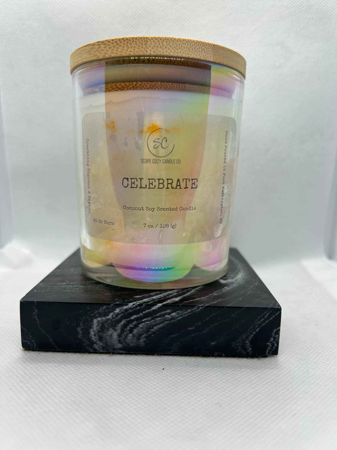 Celebrate Coconut Soy Scented Candle 7oz in glass jar with wooden lid on black marble base
