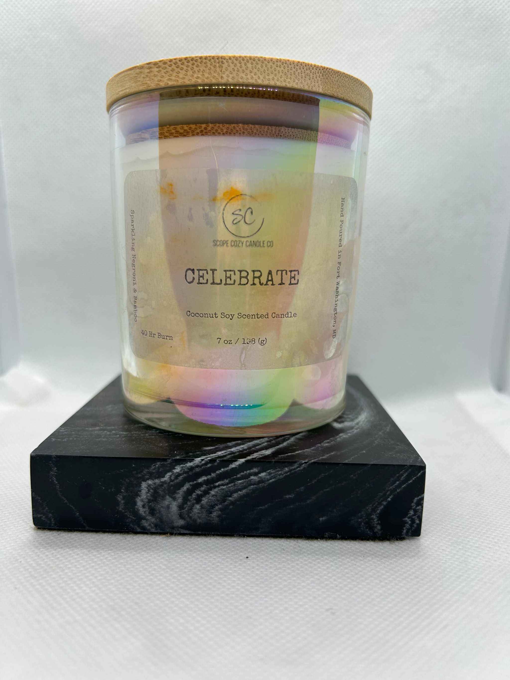 Celebrate Coconut Soy Scented Candle 7oz in glass jar with wooden lid on black marble base
