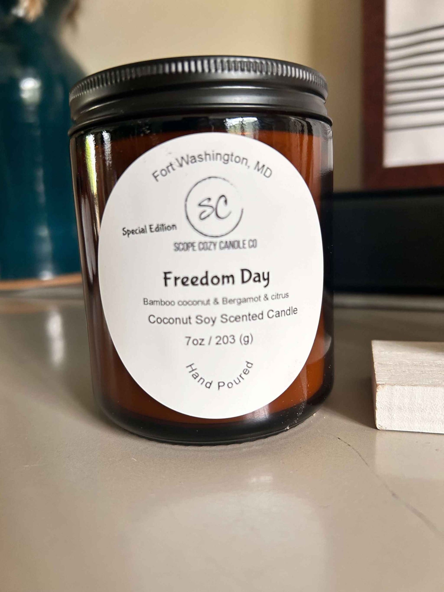 Freedom Day 7oz coconut soy scented candle with bamboo, bergamot, and citrus notes in amber glass jar