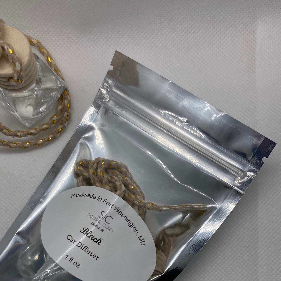 Black hanging car diffuser with black cardamom scent in silver resealable packaging