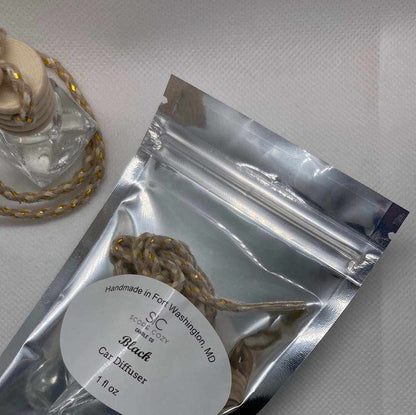 Black hanging car diffuser with black cardamom scent in silver resealable packaging